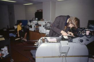 Picture of library work room with special equipment and person working at machine. 