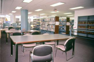 Picture of a tables and shelves in a library. 