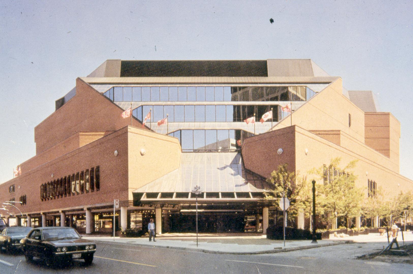 Picture of a multi storey red brick and glass library building from street. 