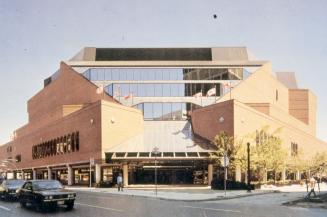 Picture of a multi storey red brick and glass library building from street. 