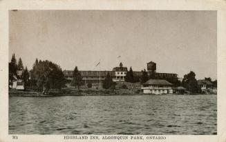 Sepia tone photograph of a three story hotel on the shoreline of a body of water.