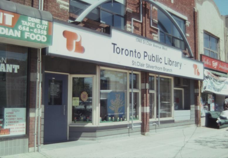 Picture of a storefront library with large sign in orange. 