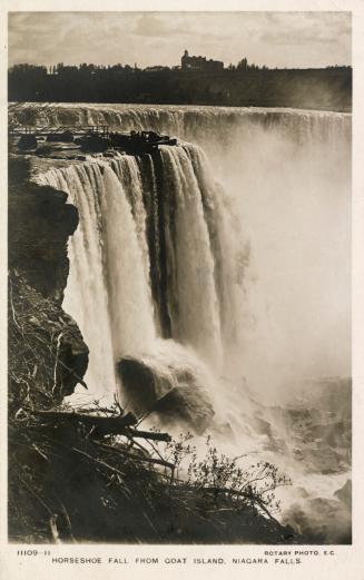 Black and white photograph of water cascading over the top of a cliff.
