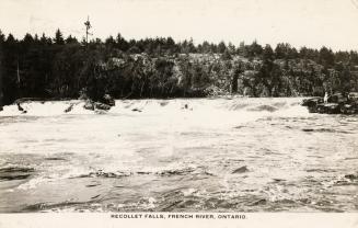 Black and white photograph of rapids in a river in a rocky area of bush.