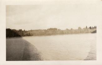 Black and white photograph of ruins taken from a boat on a body of water.