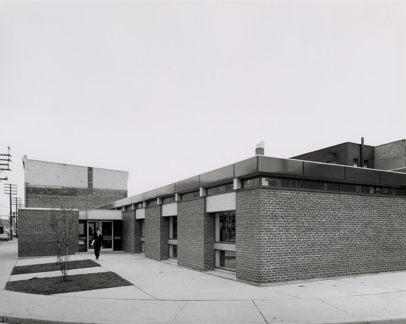 Exterior view of a one storey brick library building. 