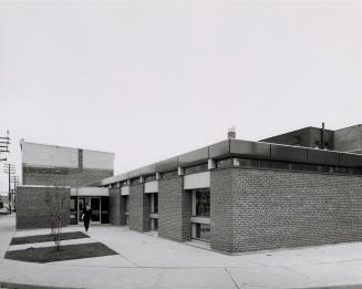 Exterior view of a one storey brick library building. 
