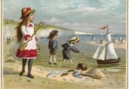 The card pictures people on a beach. A girl stands in the sand with a pail and shovel while two…