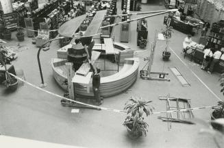 Picture of two men doing construction of round information desk in library with balconies in ba…