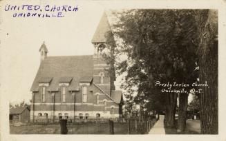 Black and white photograph of a small country church with a steeple.