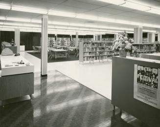 Picture of library interior showing sixties style chairs, shelving and service desk. 