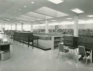 Picture of interior of 1960's library showing study carrels, card catalogue, shelving and stair…
