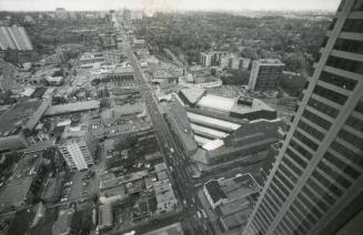 High up view of library under construction and surrounding streets and buildings. 