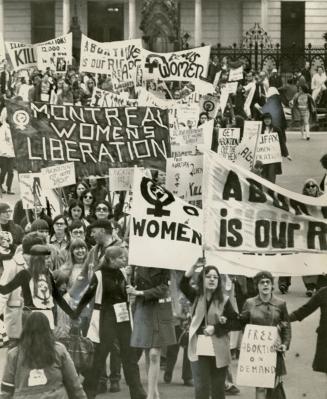 Large throng of women mostly young, carrying large banners saying, 'women's liberation' and 'ab…