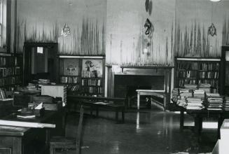 Picture of interior of library with fire damaged walls and bookshelves. 