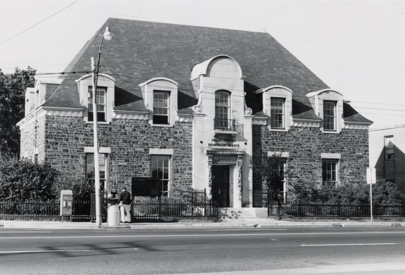 Picture of an two storey French style library building with iron fence and gardens. 