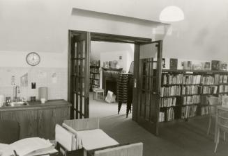 Picture of inside a library showing shelves, tables and chairs. 