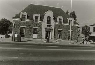 Picture of a two storey library with steep pitched roof and bellcast eaves. 