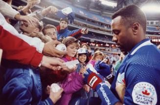 Blue Jays' injured right fielder Joe Carter autographs baseballs last night for fans at the SkyDome as Toronto prepared to play the Minnesota Twins
