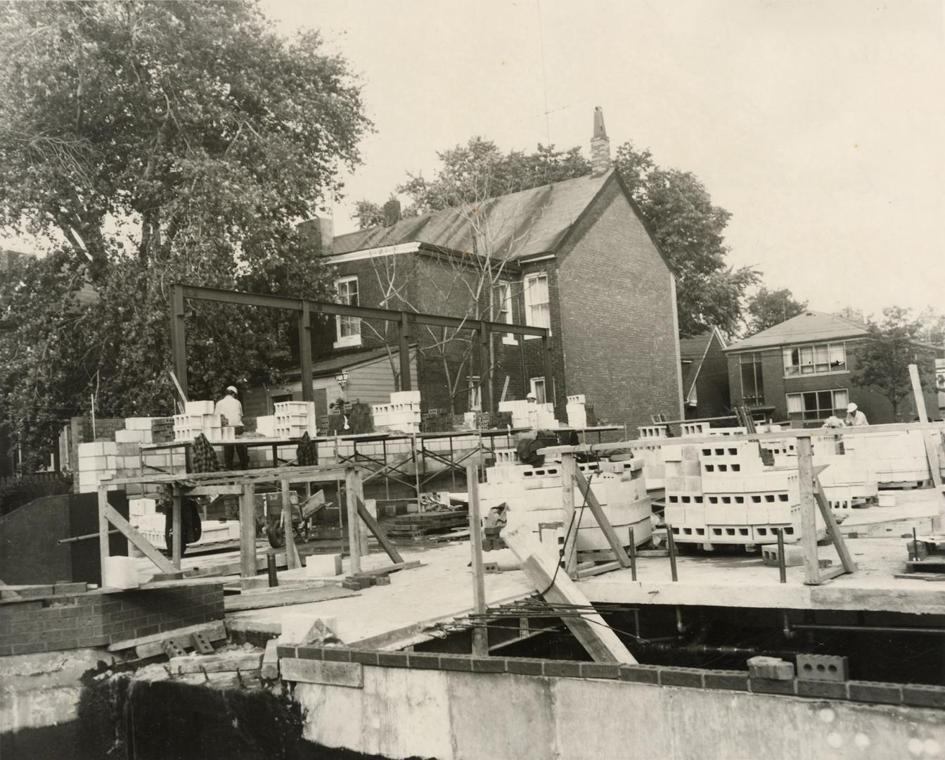 Picture of a construction site showing ground floor and concrete blocks on skids and neighbourh…