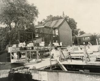 Picture of a construction site showing ground floor and concrete blocks on skids and neighbourh…