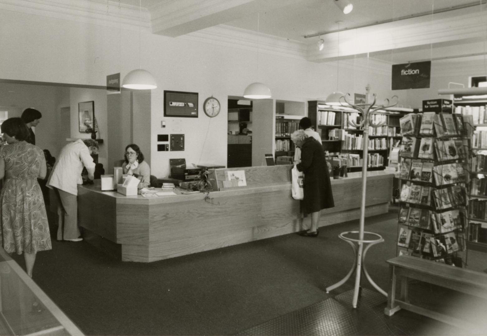 Picture of inside a library showing shelves, tables and chairs. 