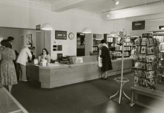 Picture of inside a library showing shelves, tables and chairs. 
