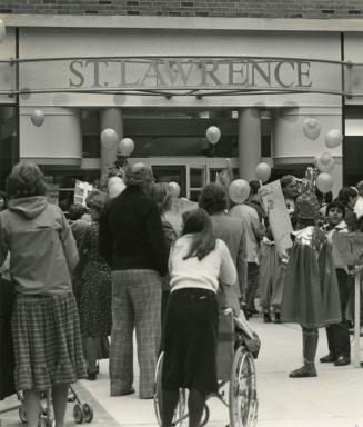 Picture of a crowd of people holding balloons and standing outside the front door of St. Lawren…