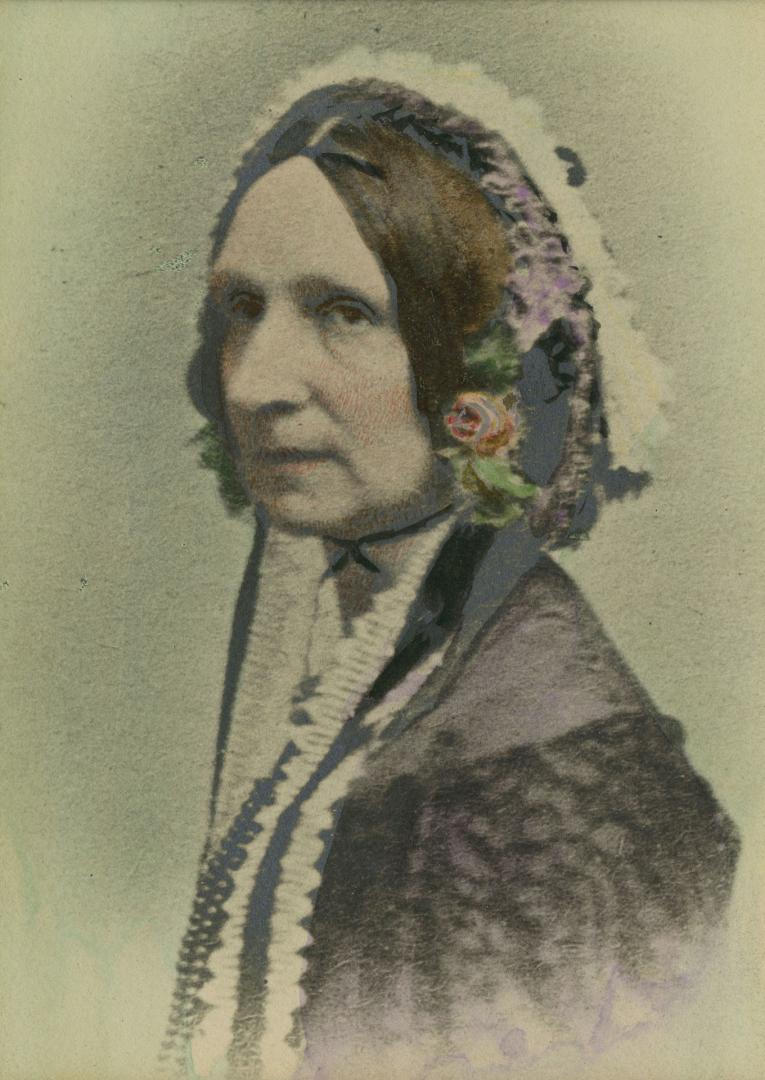 Hand-coloured photograph of a 19th-century woman seated for a 45-degree profile portrait wearin…
