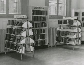 Picture from two free standing A shaped library shelves and one shelf against a wall all with s…