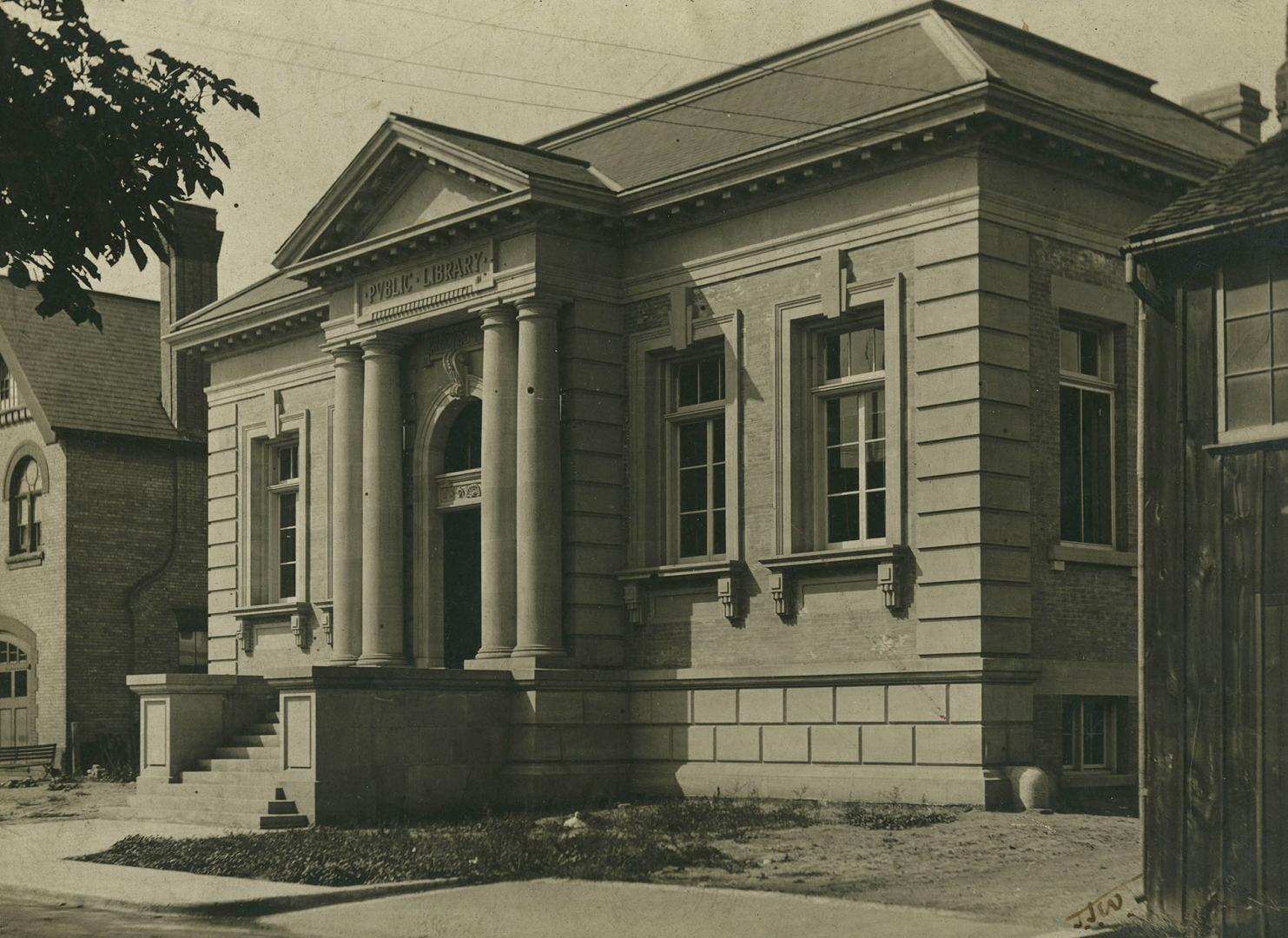 Picture of a one storey stone library building with four pillars and portico. 