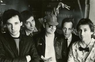 5 young men in a row, torso and head, all with short dark hair and dark eyes.