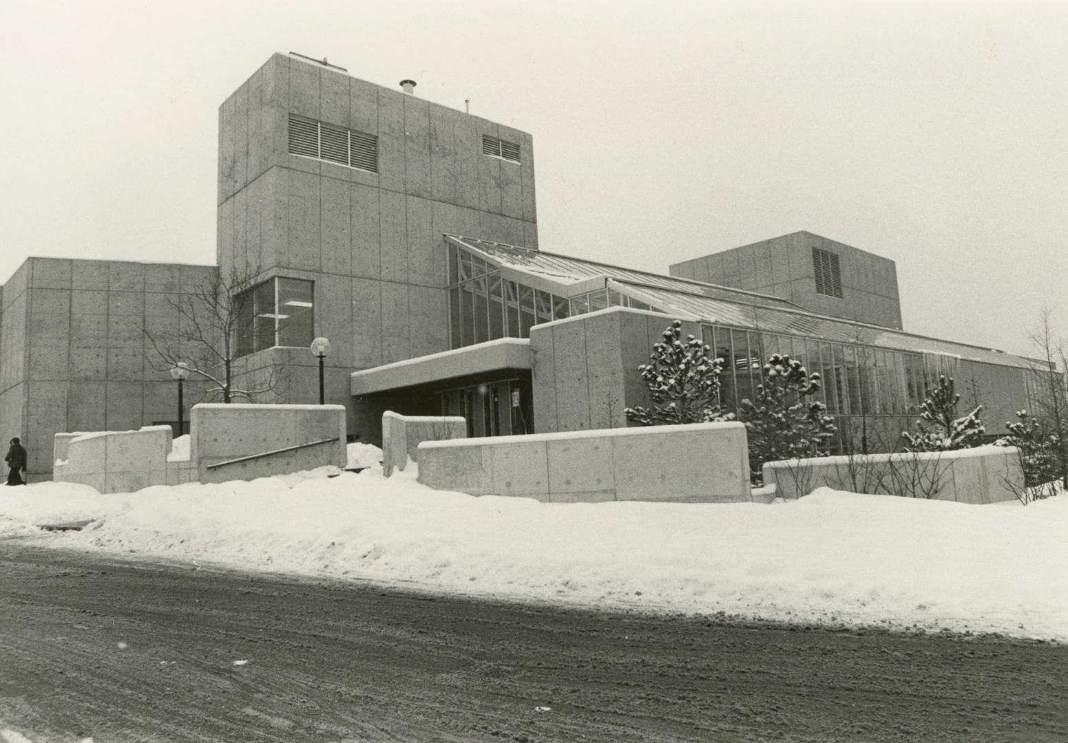 Picture of concrete library building with snow on ground. 