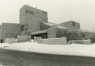 Picture of concrete library building with snow on ground. 