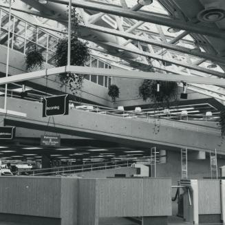 Picture of interior of a library showing turnstiles and glass and steel ceiling. 