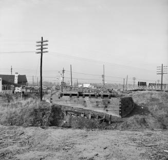 Photograph of construction of wooden bridge over railway line. 