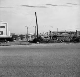 Photograph of wooden bridge over railway line. 