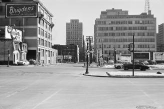 Photograph of wide intersection with buildings on both sides. 