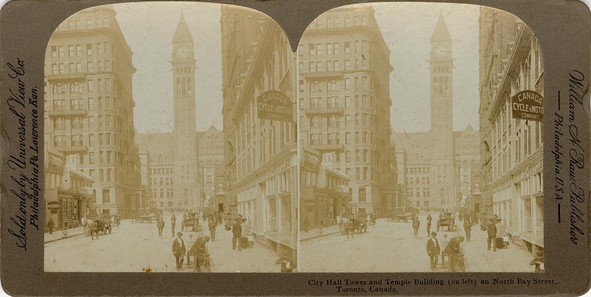 Pictures show a busy city street with a clock tower of an large government building in the back…