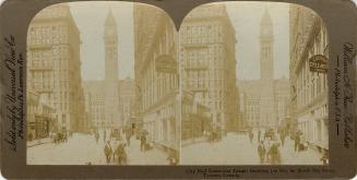 Pictures show a busy city street with a clock tower of an large government building in the back…