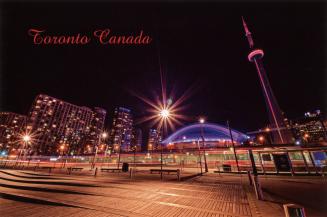 Nighttime photo of Toronto, with the CN Tower illuminated in pink to the right and the Rogers C…