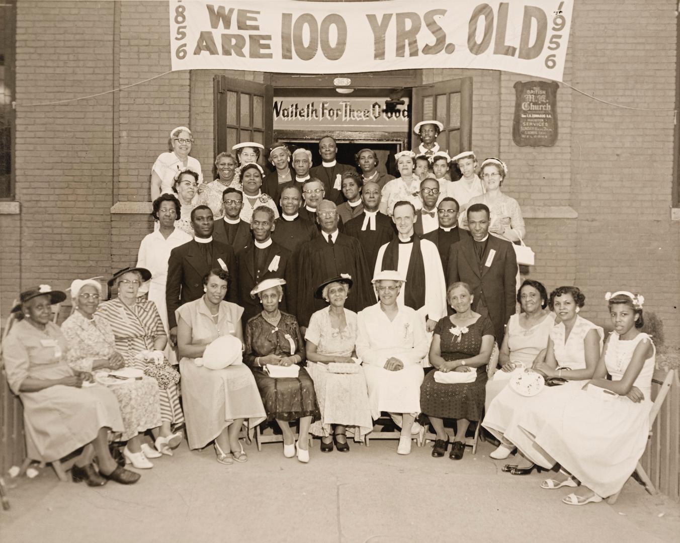 Black-and-white group photograph of approximately thirty adults arranged in several rows on the…