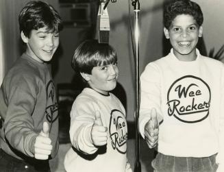 Three young boys give the thumbs up all wearing Wee Rockers sweatshirts. 