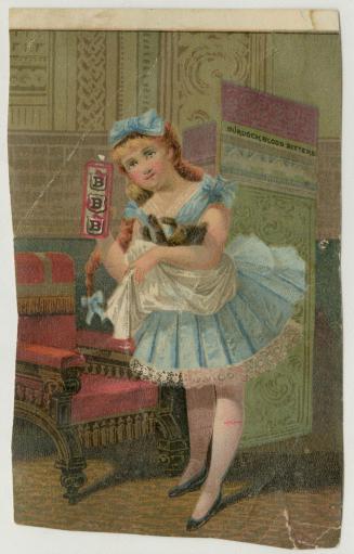 A young girl in a pretty blue dress with matching bows in her hair cradles a cat in her arm. In ...