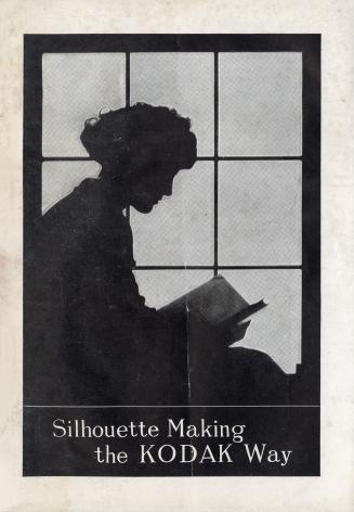 Silhouette of a woman reading a book by a window