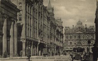 Black and white photograph of a city street with tall building on either side. Large, Second Em ...