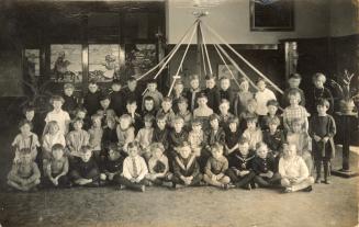 Black and white photograph of 53 school children posing in their classroom.