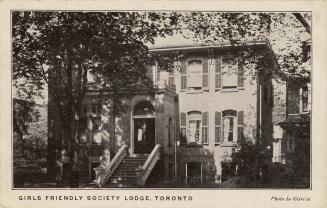 Black and white photograph of a two story house with shutters on the windows.
