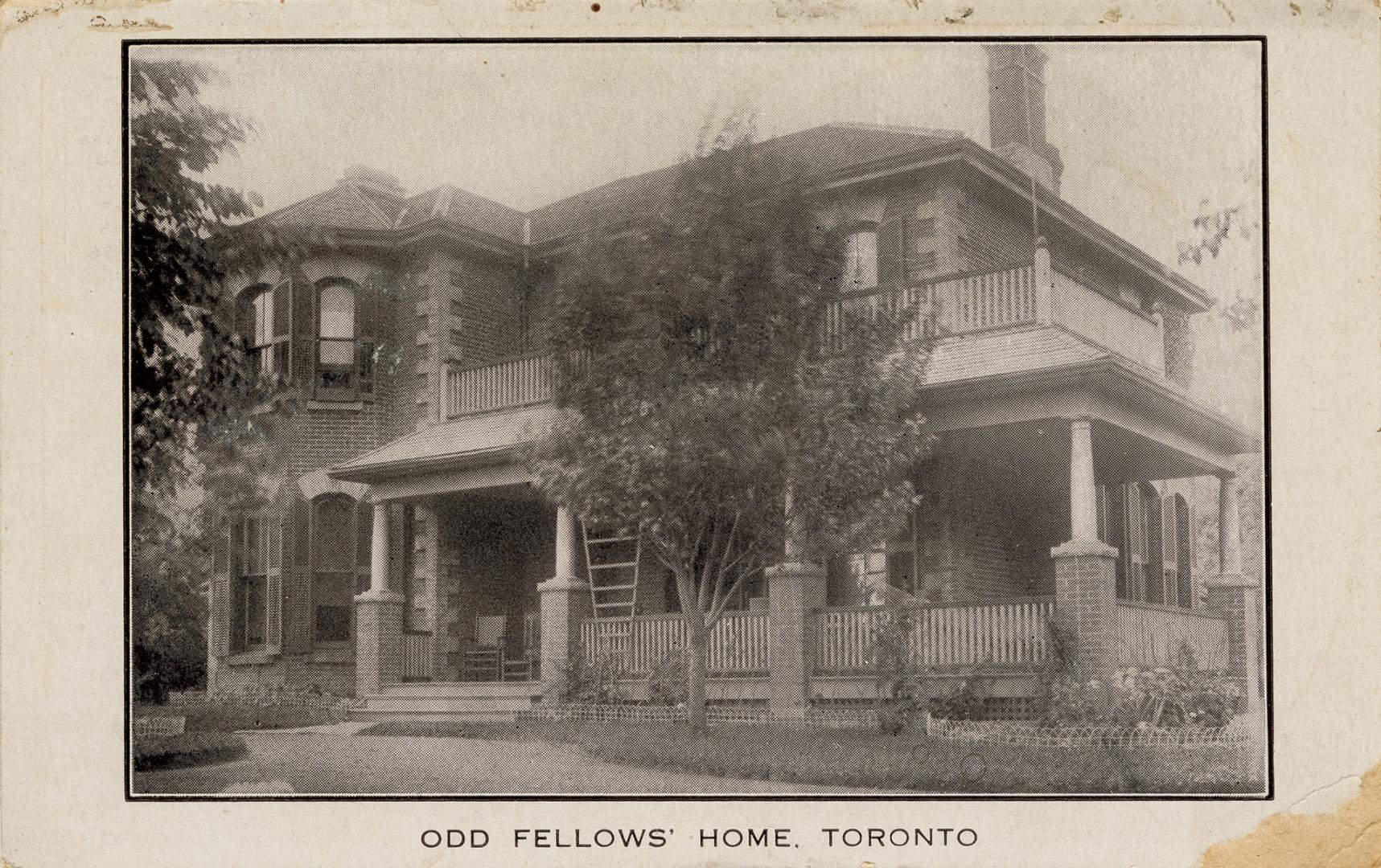 Black and white photograph of a two story house with shutters on the windows.